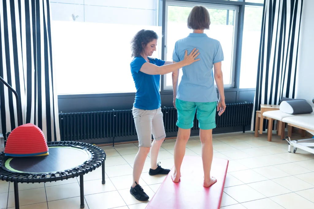 S. Steglich Chefin der Physiotherapie zeigt einer Patientin bei einer Übung die richtige Haltung.