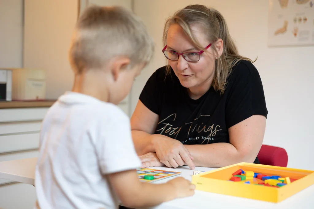 Ergotherapeutin behandelt Kind - sensomotorisch perzeptive Behandlung.