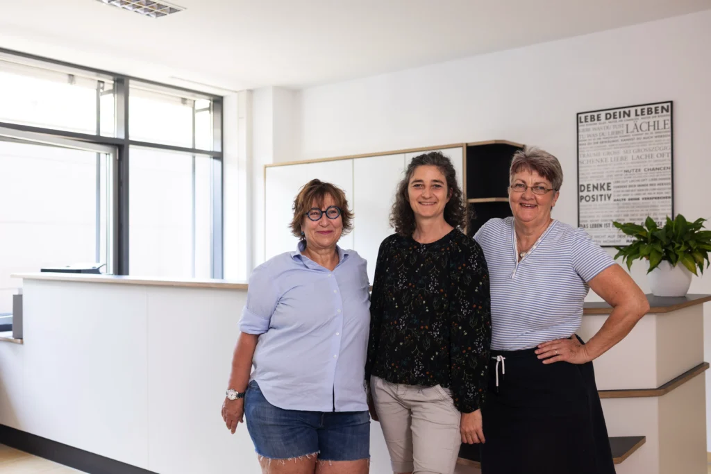 Chefinnen der Praxis für Ergo- und Physiotherapie stehen vor dem Tresen am Empfang